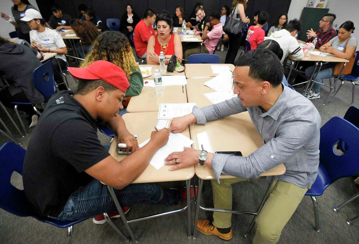 Thomas Agosto, dean of students for Stamford High School, helps Westhill High School graduate Robinson Reyes fill out college forms on June 20, 2019. Agosto’s position was cut earlier this summer, but the Board of Education was able to bring it back on Tuesday.