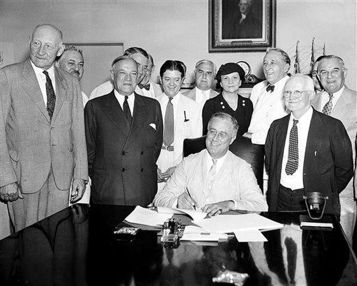 FILE - This Aug. 14, 1935, file photo shows President Franklin D. Roosevelt signing the Social Security Bill in Washington. As Social Security approaches its 80th birthday on Aug. 14, 2015, the federal government's largest benefit program faces serious financial problems that could be fixed with only modest changes, if Congress acts quickly. (AP Photo, File)
