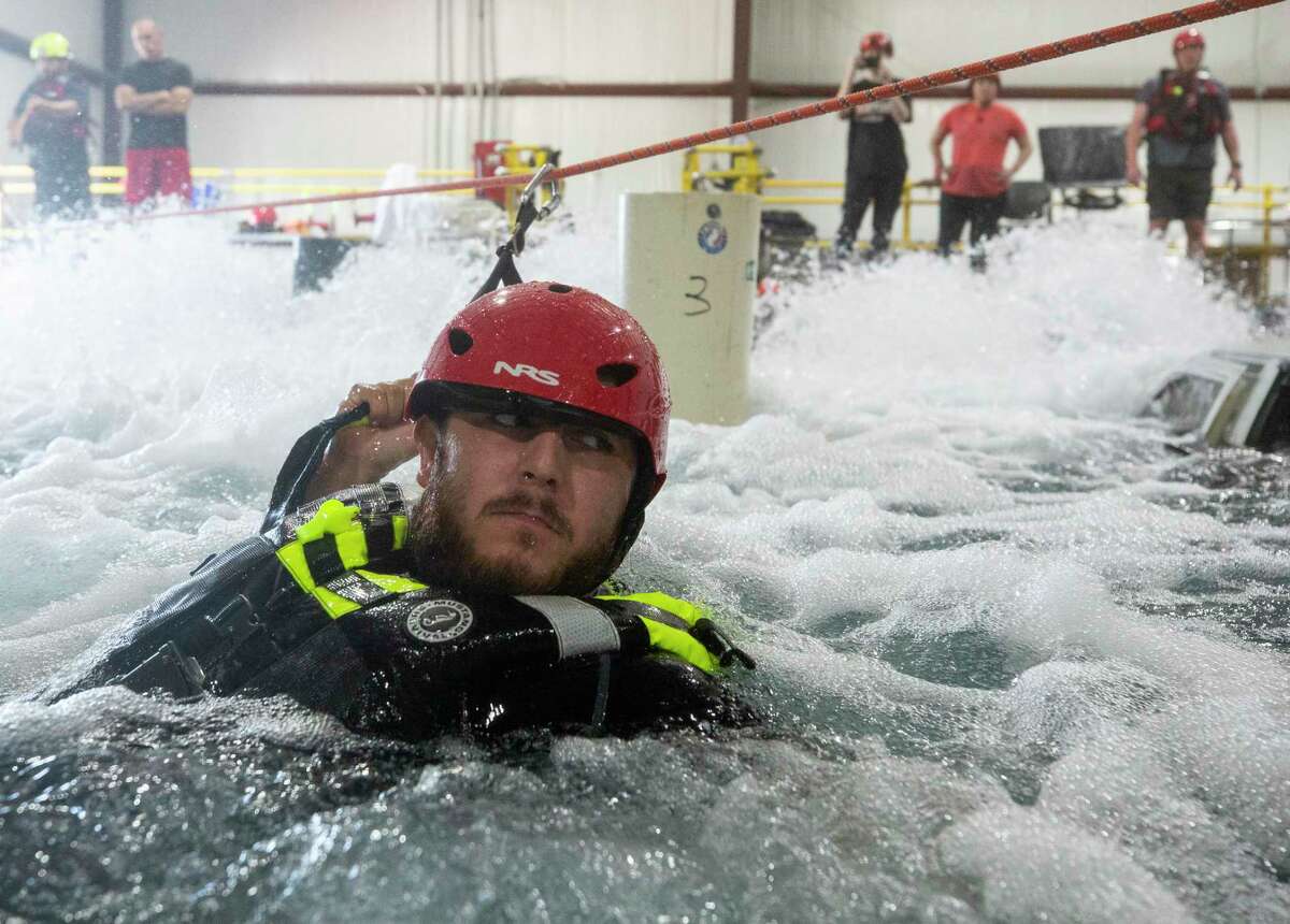 Harris County Sheriff's Office deputy Mark Barboza makes his way to a flooded vehicle using a line secured on both side of the water, during a swift water rescue training at Fathom Academy on Monday, Aug. 10, 2020, in Georgetown, Texas.
