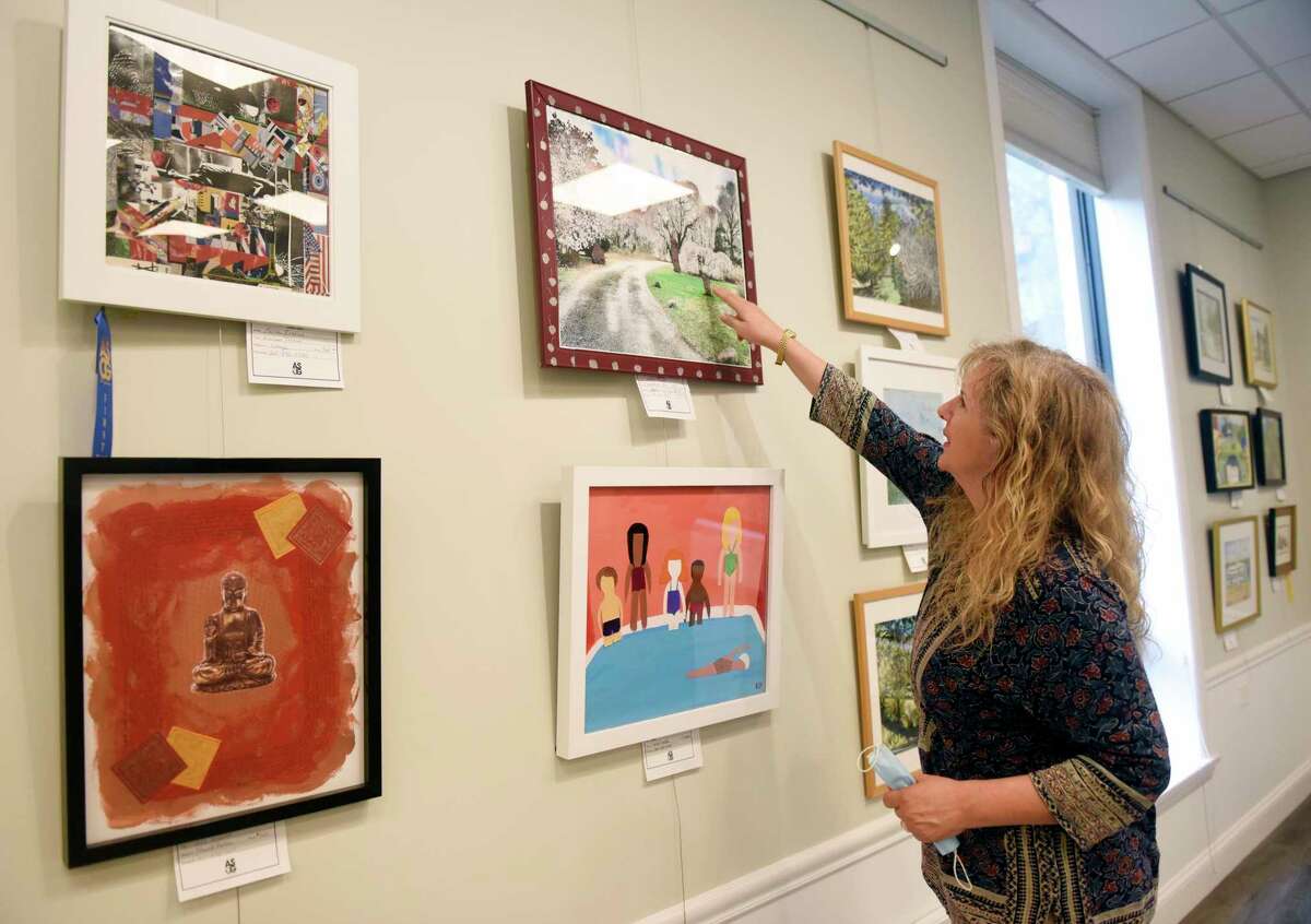 ASOG board member and exhibit co-chair Reese Anderson Green points out mixed media pieces displayed in the Art Society of Old Greenwich Summer Pop-Up Exhibit at the Greenwich Botanical Center in the Cos Cob section of Greenwich, Conn. Thursday, Aug. 13, 2020. 63 pieces from 37 local artists are on display and for sale in the show, which was judged by Parsons School of Design art history professor Barbara M. Laux, Ph.D. The reception, featuring live music by Chris Fiore, will be held with mandatory masks and social distancing on Saturday, Aug. 15 at 3 p.m.