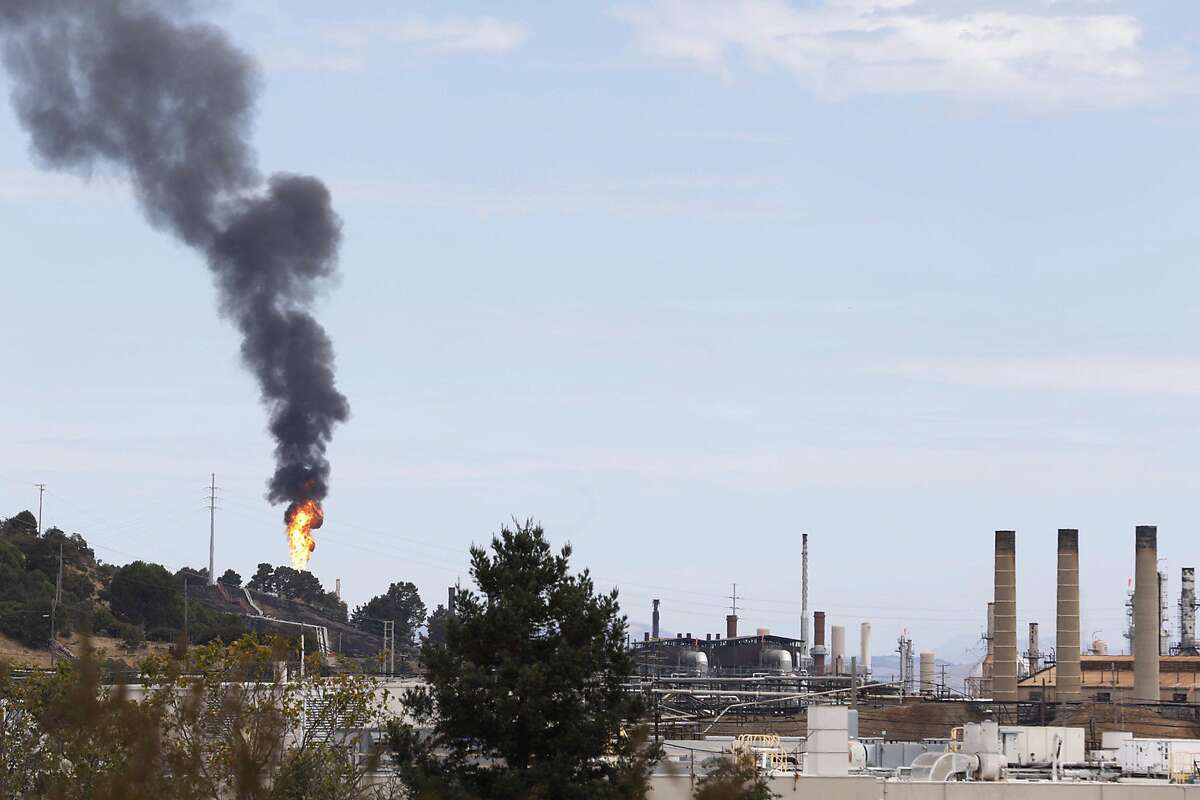 smoke and flames shoot yo from a building near the Chevron oil refinery in Richmond, Calif. Friday, August 24, 2020.