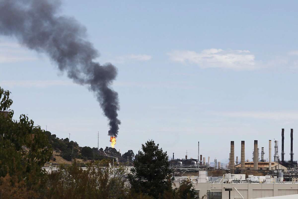 smoke and flames shoot yo from a building near the Chevron oil refinery in Richmond, Calif. Friday, August 24, 2020.