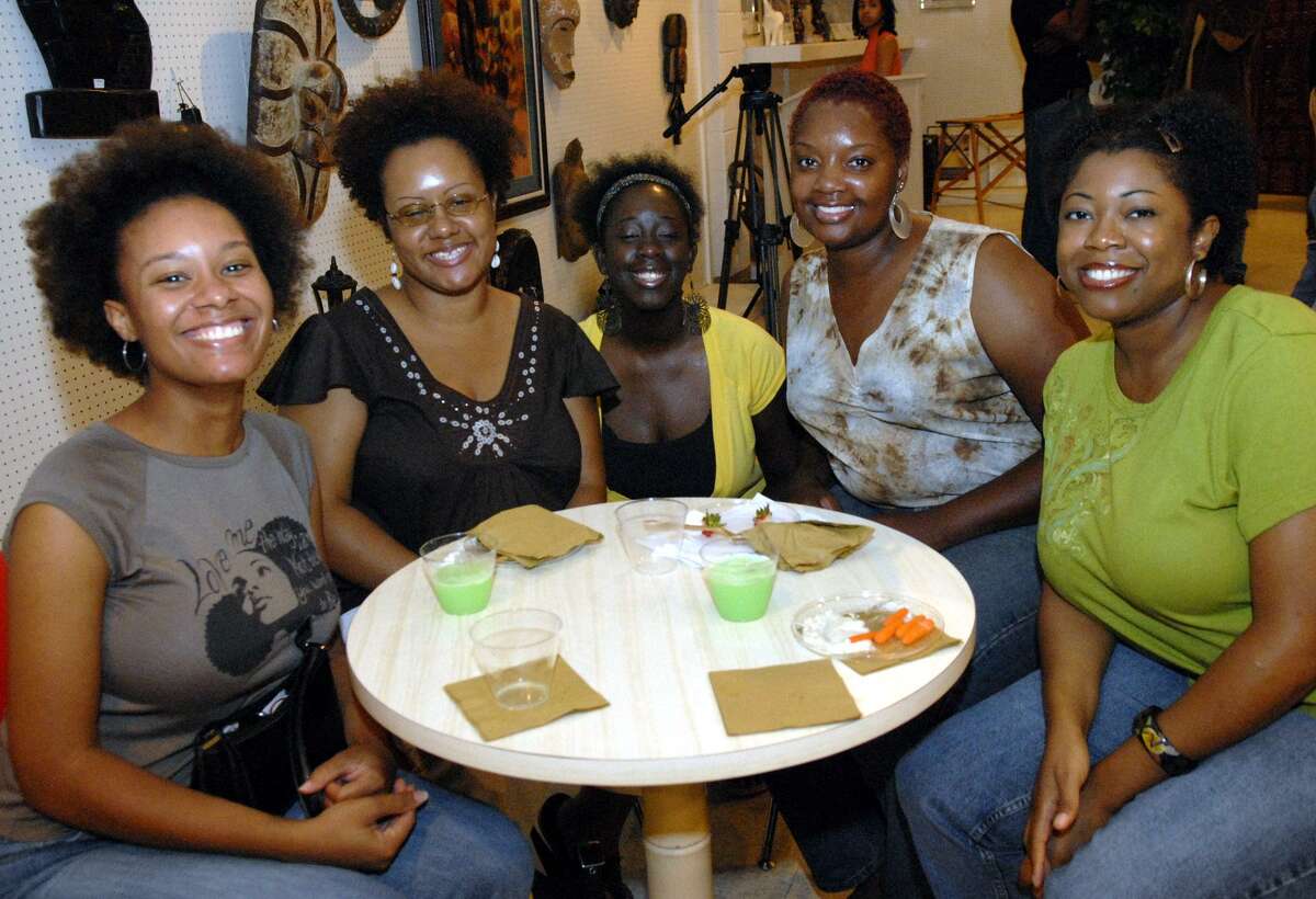 A group of women show off their natural hair during a meet-and-greet gathering at a documentary about black women and men who choose to wear their hair natural in Houston.