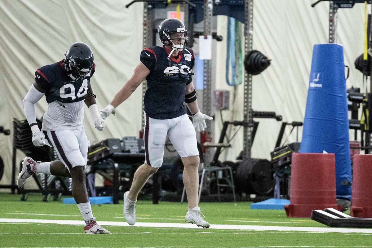 Houston Texans defensive ends Charles Omenihu (94) and J.J. Watt (99) run a drill during an NFL training camp football practice Friday, Aug. 14, 2020, at The Houston Methodist Training Center in Houston.