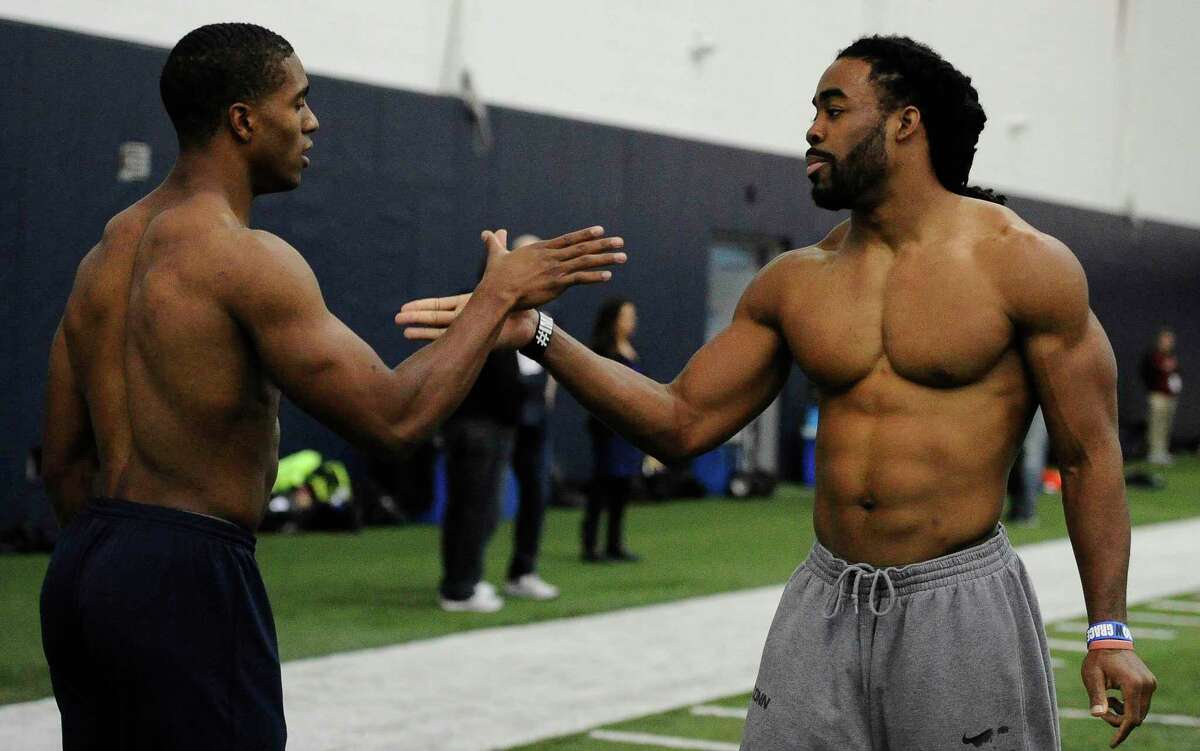 Byron Jones, left, and Geremy Davis, right, slap hands during Connecticut’s NFL pro day in 2015. Jones is in his first season with the Miami Dolphins while Davis joined the Detroit Lions in the offseason.
