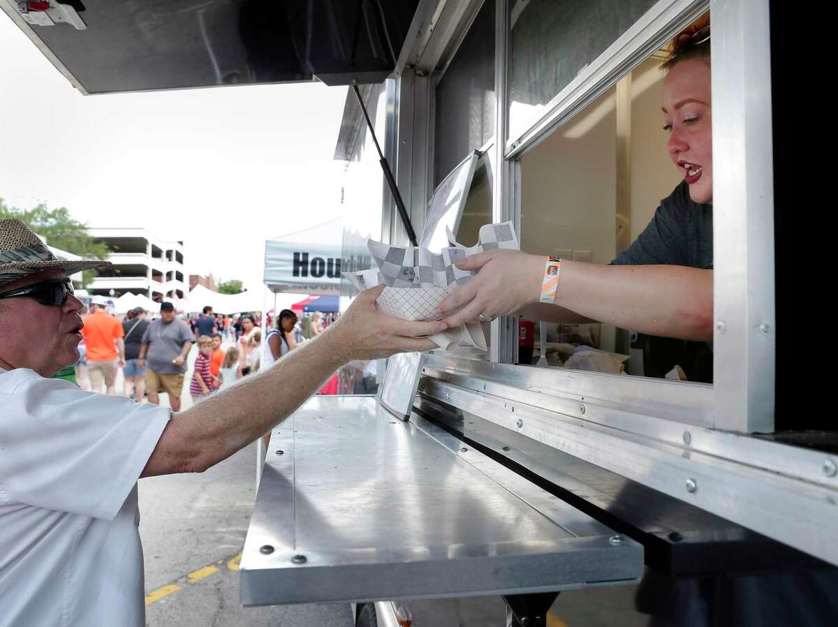Lauren Smith, right, hands out tacos to customers from the Pacific Yard House food truck during The Second Annual Texas Taco, Tequila, and Margarita Festival held Saturday, Sep. 8, 2018 in Heritage Park in Conroe.