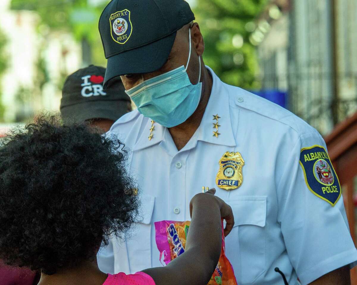 A residents of First Street points to Albany Police Chief Eric Hawkins’ badge during a walk through the West Hill neighborhood in Albany, NY, with beat cops and members of the clergy to help build bonds between themselves and the community on Friday, Aug. 14, 2020 (Jim Franco/special to the Times Union.)