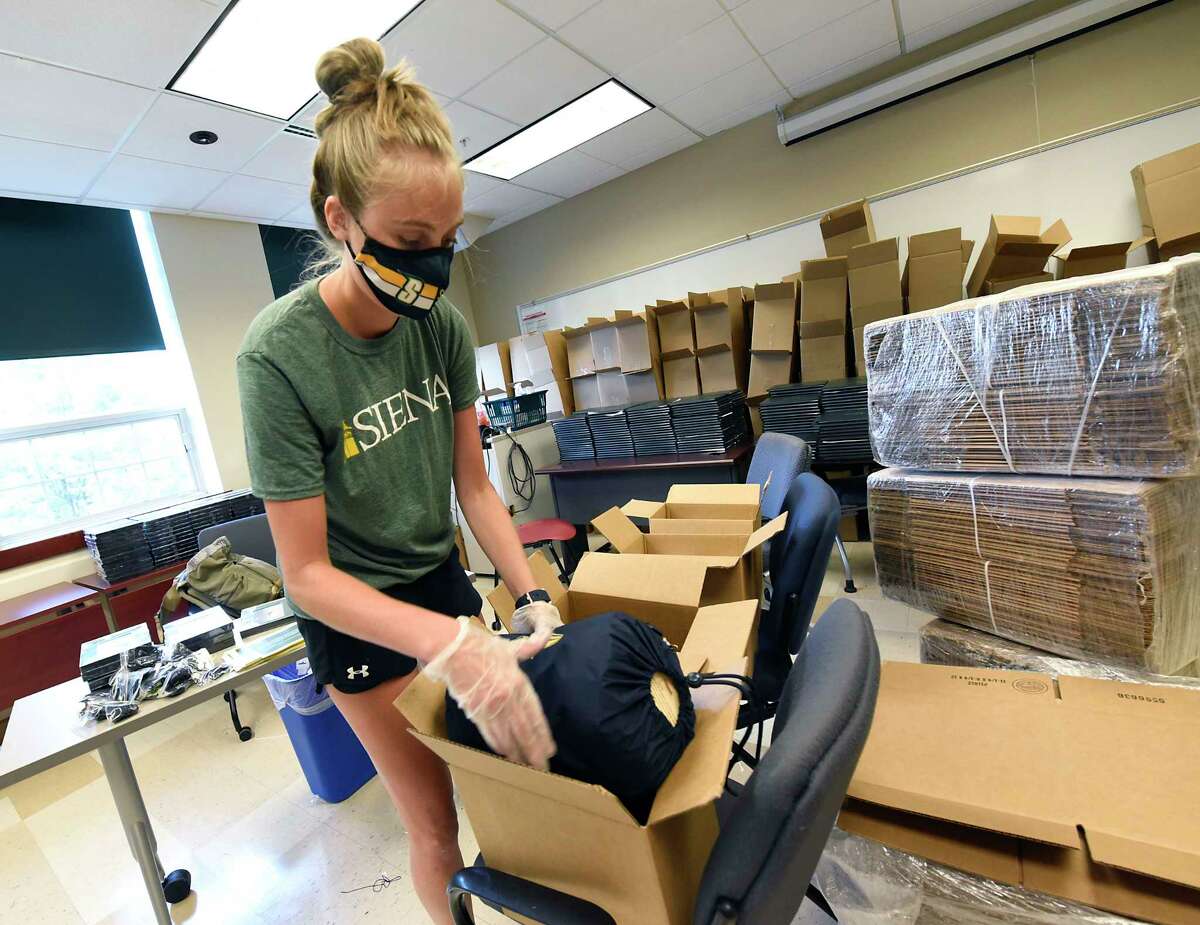 2013 Alumnus Elizabeth Ives, of Siena's Academic Affairs, helps pack gift boxes at the college to mail to the graduates on Friday, Aug. 14, 2020 in Colonie, N.Y. The gift boxes, which were mailed to take some of the sting out of the cancellation of commencement, include Siena logo blankets donated by Pretty Rugged, diploma covers, mortarboard tassels, a letter from Siena President Dr. Christopher Gibson, a photo frame and the graduation program. (Lori Van Buren/Times Union)
