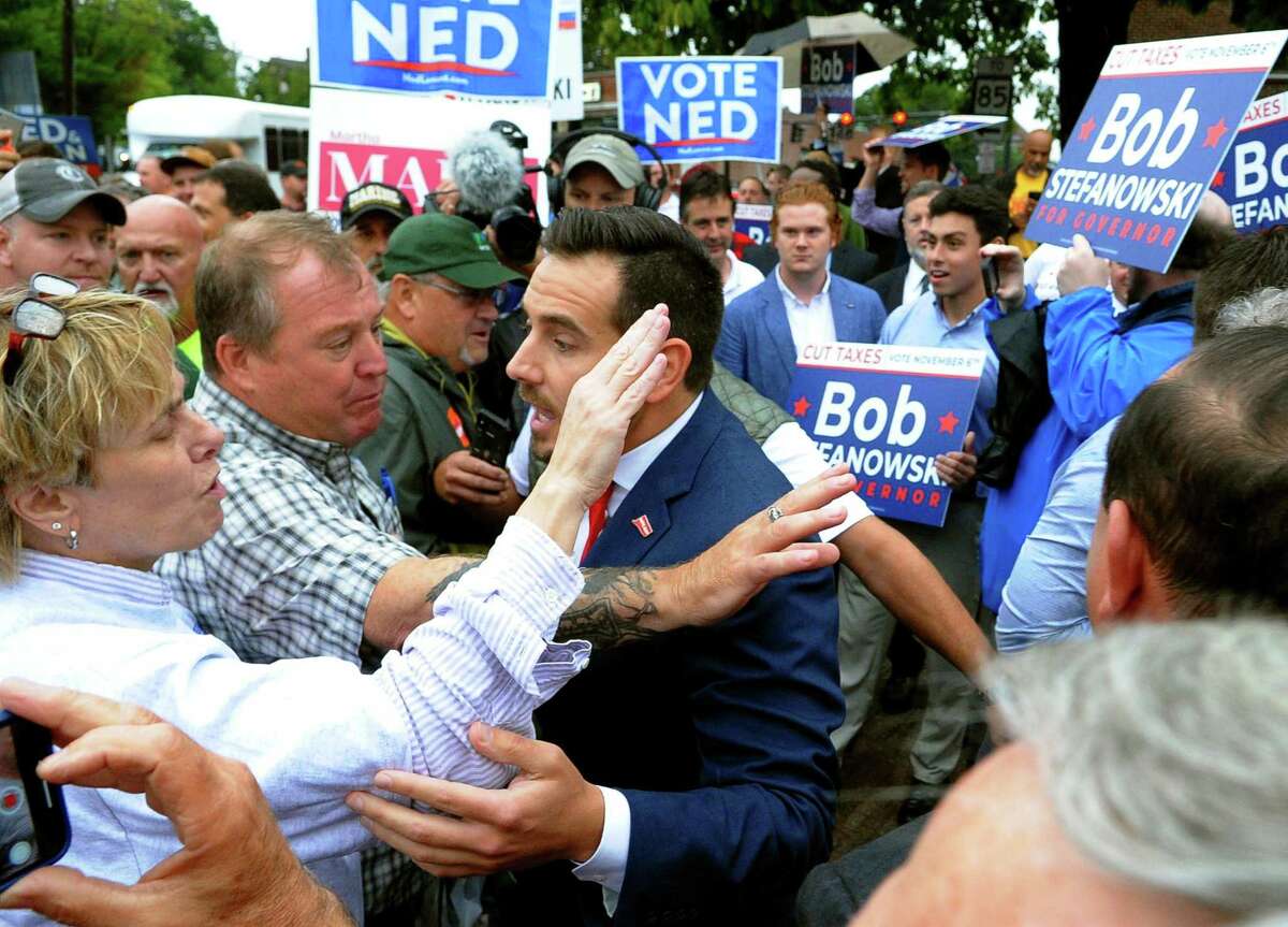 Then-state Republican Chairman J.R. Romano, center, mixed it up with Ned Lamont supporters ahead of a debate for governor in 2018 in New London.