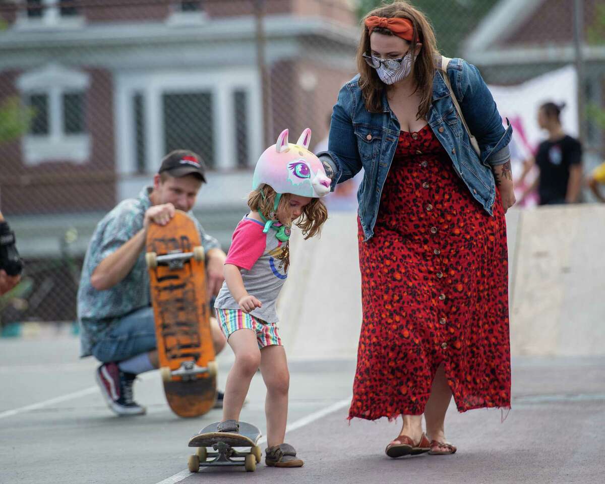 Brendon Benack, of Noteworthy Resources, watches Mary Rees help Hazel Rees get on a skateboard during an event hosted by NWR to introduce women, youth, members of the LGBTQ+ community and their allies to the sport of skateboarding at the Albany Skate Park in Washington Park in Albany, NY, on Saturday, Aug. 15, 2020 (Jim Franco/special to the Times Union.)
