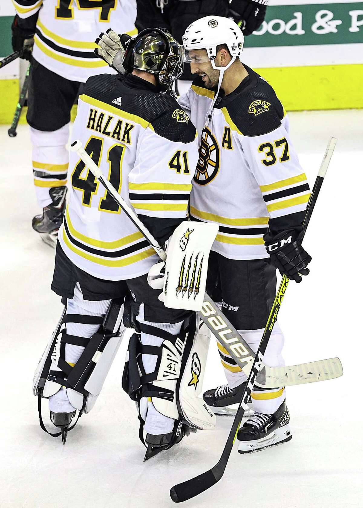 TORONTO, ONTARIO - AUGUST 15: Jaroslav Halak #41 and Patrice Bergeron #37 of the Boston Bruins celebrate their teams 3-1 win against the Carolina Hurricanes in Game Three of the Eastern Conference First Round during the 2020 NHL Stanley Cup Playoffs at Scotiabank Arena on August 15, 2020 in Toronto, Ontario. (Photo by Elsa/Getty Images)