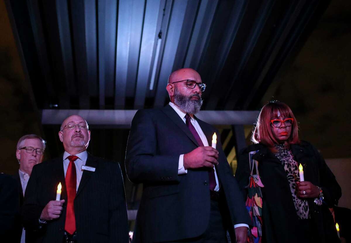 Fort Bend Independent School District Superintendent Charles Dupre, center, and others take part in a candlelight vigil to honor 95 African-Americans whose remains were found at a Sugar Land construction site, at the James Reese Career and Technical Center on Sunday, Nov. 17, 2019, in Sugar Land. The Fort Bend ISD in September 2020 released a report with information on 72 of those whom they believe to be buried on the site.