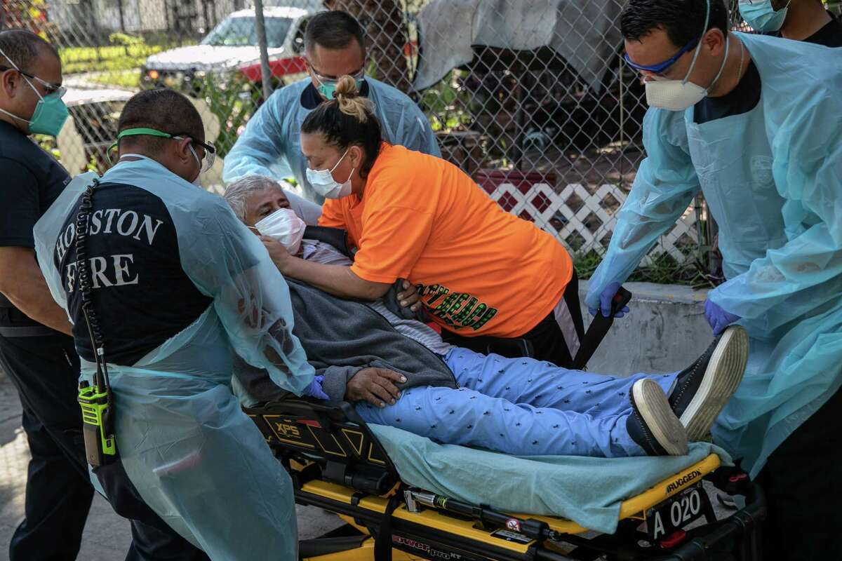 HOUSTON, TEXAS - AUGUST 13: A woman embraces her husband with possible Covid-9 symnptoms before medics with the Houston Fire Department EMS transported him to a hospital on August 13, 2020 in Houston, Texas. Several of the man's family members, including the wife, had also tested positive. The Latino community in Houston has been especially hard-hit during the coronavirus pandemic. (Photo by John Moore/Getty Images)