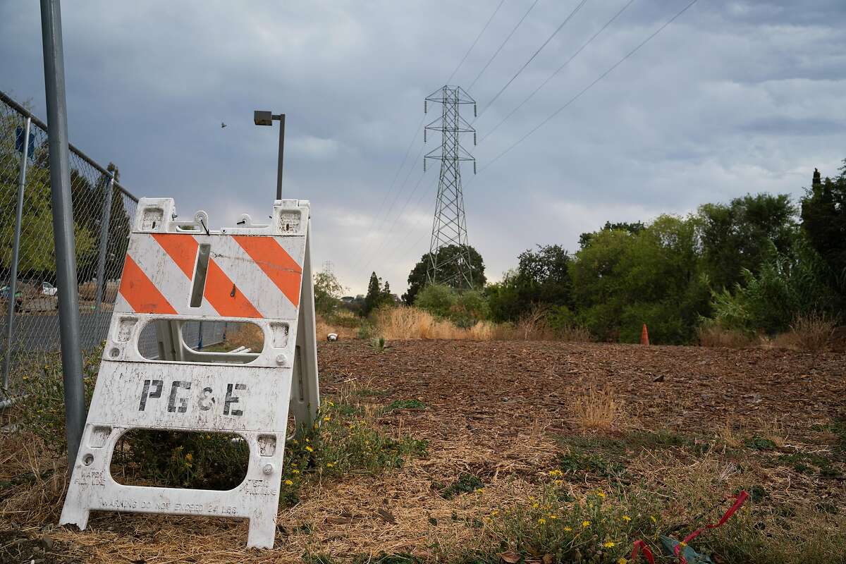 A PG&E sign is placed near power lines on Palm Avenue and Vista Way in Martinez, Calif., on Sunday, August 16, 2020. California has ordered rolling power outages for the first time since 2001 as a statewide heat wave strained its electrical system.