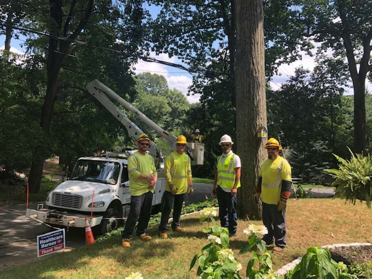 A crew from Sumter Utilities of Ashville, N.C., contracted by Eversource, restores power to a home in in Wilton on Aug. 12, 2020.