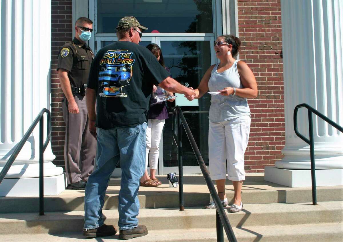 Jeff Jurik, husband of candidate for Dover Treasurer Crystal Jurik, congratulates Amanda Bailor after she was declared the winner of the August primary election by drawing a paper with the word "NOMINATED" on it at the Lake County Courthouse on Aug.14. Bailor will now move on teh the November election. (Pioneer photo/Cathie Crew)