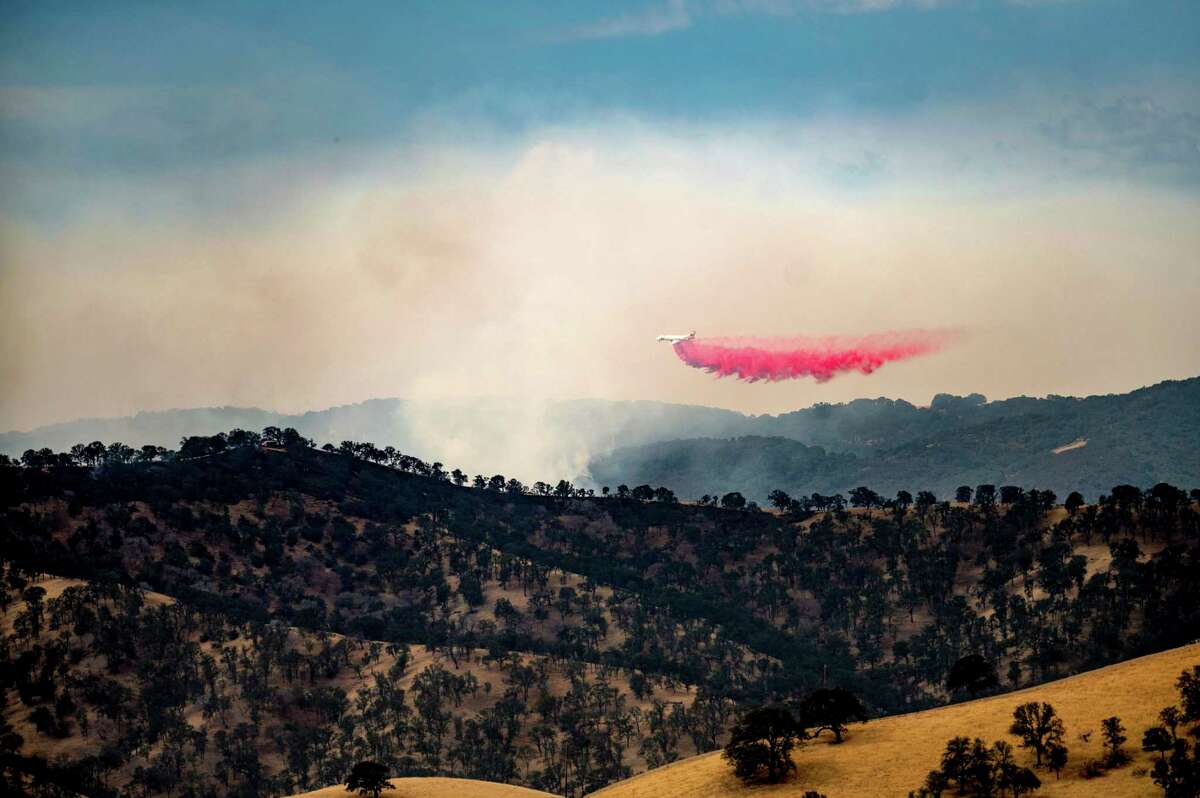 An air tanker drops retardant while battling one of several wildfires comprising the Deer Zone fires a unincorporated Contra Costa County, Calif., on Sunday, Aug. 16, 2020. Firefighters scrambled to contain multiple blazes, sparked by widespread lightning strikes throughout the region, as a statewide heat wave continues.