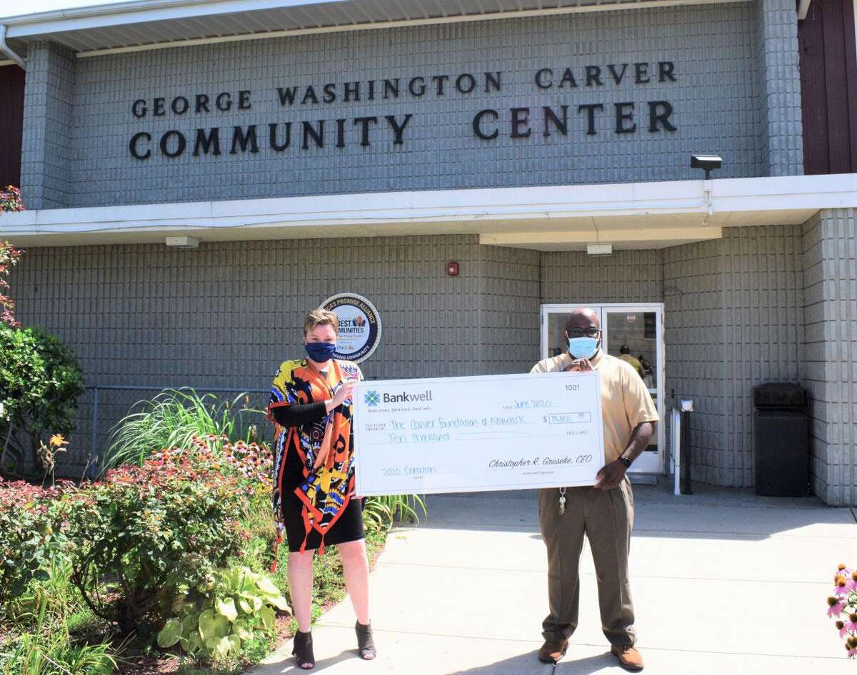 From left, Lucy French, vice president and marketing manager at Bankwell presents a $10,000 check to Brian Allert, chief program officer at the Carver Foundation of Norwalk for the benefit of students in Carver's after-school programs.