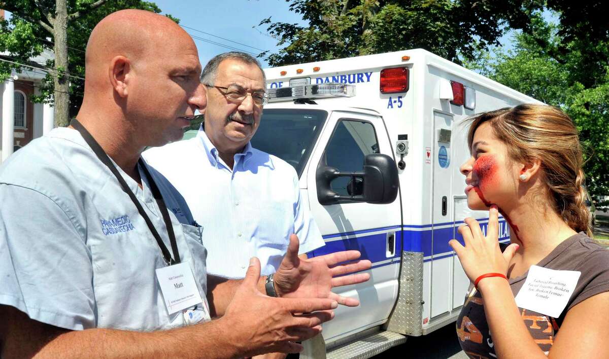 Matthew Cassavechia, director of emergency medical services for Danbury Hospital, left, and Dr. Richard Aghababian, an expert in disaster medicine, talk with Grecia Almanzar, 15, a Police Explorer volunteer playing the role of a tornado victim during a pediatric disaster life support and simulated F-4 tornado strike on a school, held at Danbury City Hall, Saturday, June 5, 2011.