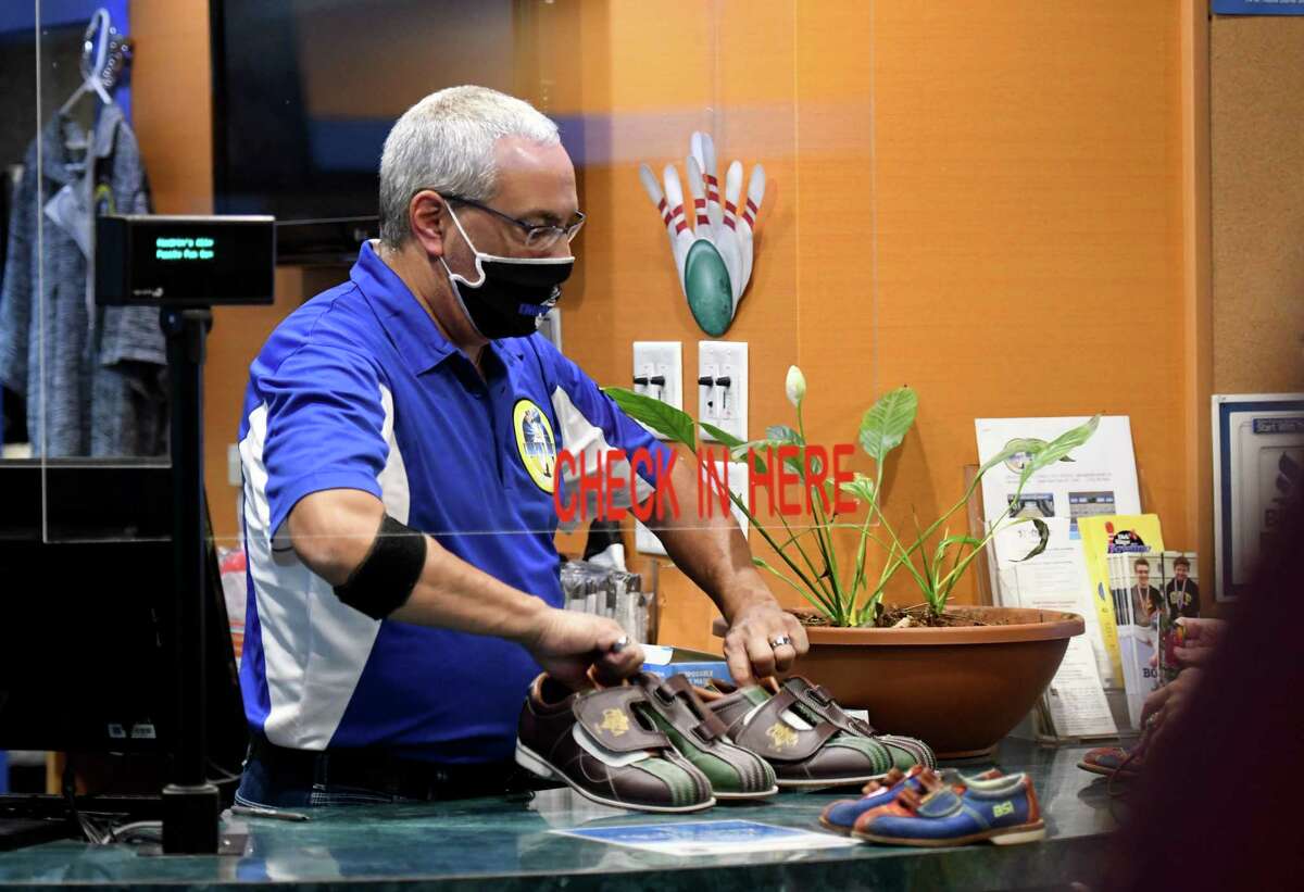 Doug Bohannan, owner of Kingpin's Alley, pulls out some rental bowling shoes for a customer during the first day of reopening for bowling centers under the state's coronavirus guidelines on Monday, Aug. 17, 2020, at Kingpin's Alley in South Glens Falls, N.Y. (Will Waldron/Times Union)