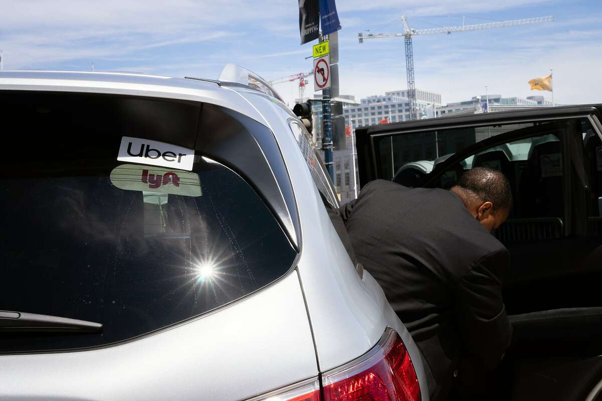 FILE -- A passenger exits a rideshare car in San Francisco on June 28, 2019. Uber and Lyft have separately discussed plans to license their technology to those who want to operate fleets of ride-hailing cars in California. (Sarahbeth Maney/The New York Times)