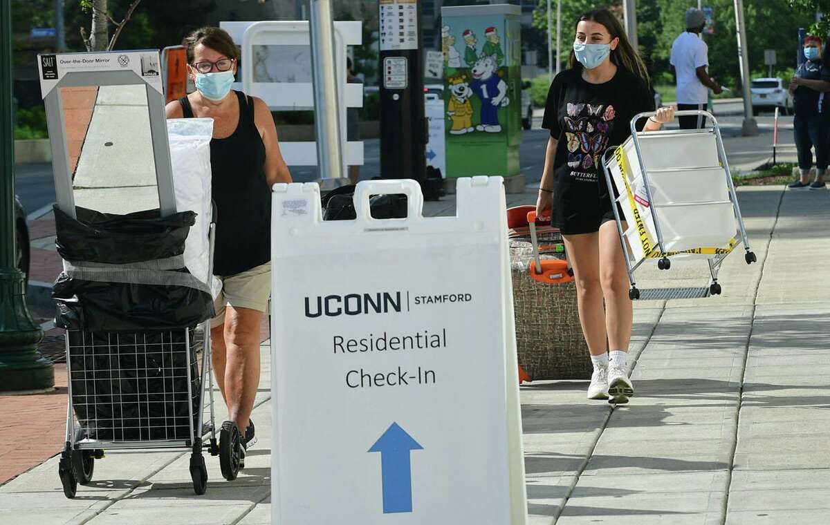 About 265 Stamford UCONN students including freshman Sophia Magrone accompanied by her mom, Mary Jo Magrone, of Bethel, center, move into the 900 Washington BLVD residence hall Friday, August 14, 2020, in Stamford, Conn. Students received specific arrival times to help stagger the amount of people in each building at any particular time as part of a COVID protocol. About 5,500 students will be moving into Storrs residence halls Friday through Monday.