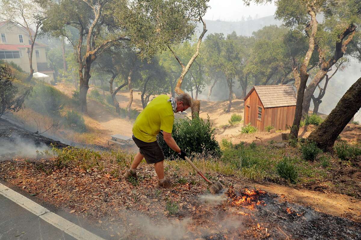 Kenny Wainright, whose family has run the Nichelini Winery for 130 years, puts out a spot fire near his great-grandparents' cabin at the winery which was threatened by the Hennessey Fire near St. Helena, Calif., on Tuesday, August 18, 2020.