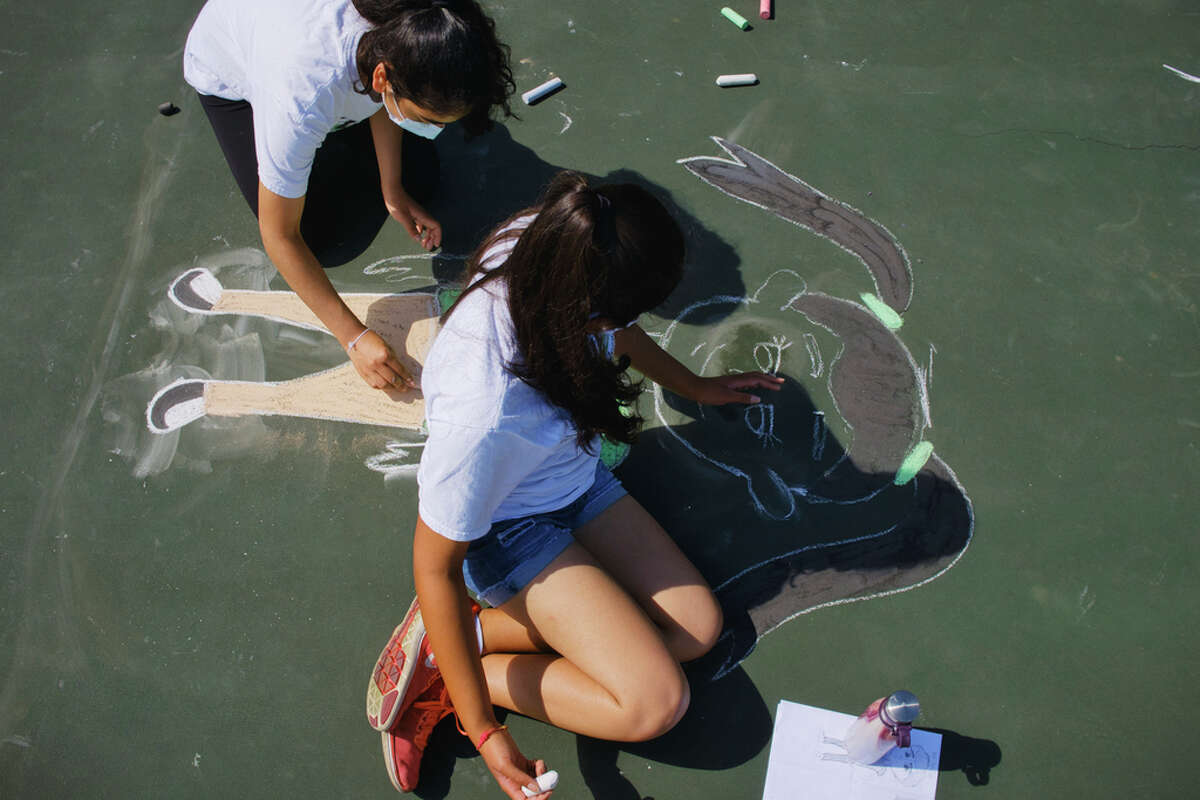 Sisters, Millee Modasra, 16, left, and Anjalee Modasra, 17, work on their chalk drawing during the 15-LOVE art project called "10 Blocks" at the Westland Hills Tennis Courts on Wednesday, Aug. 19, 2020, in Albany, N.Y. The purpose of the art project is for past and present students to create artwork that focuses on multiculturalism and racial equality. 15-LOVE provides free tennis lessons and educational opportunities to inner-city children in the Capital Region. The 15-LOVE program was able to operate this year but changed where they ran instructions from 9:30am to 8:30pm, with each class being one hour and accommodating four children on the court. (Paul Buckowski/Times Union)
