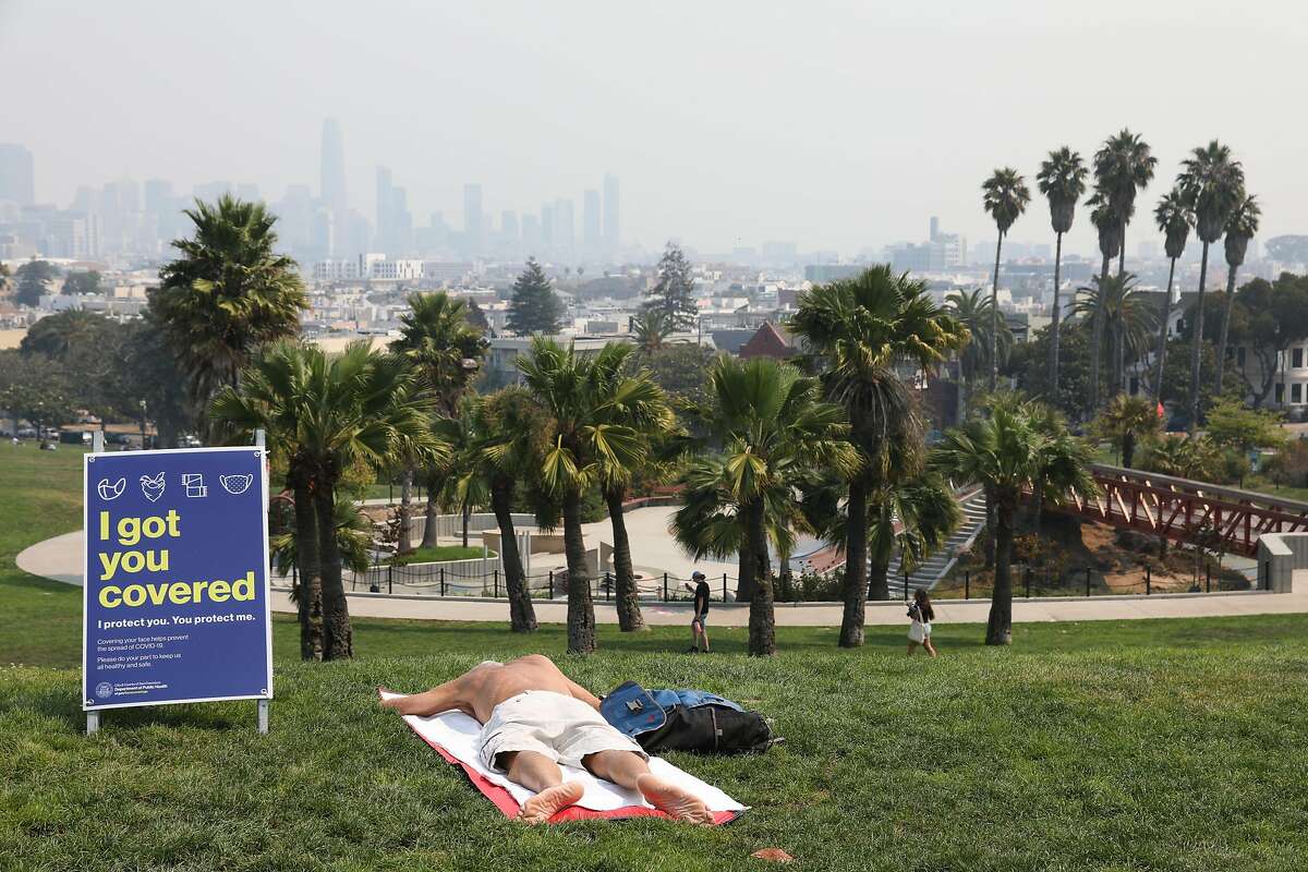 Wildfire smoke covers the skies seen toward downtown from Dolores Park on Wednesday, Aug. 19, 2020, in San Francisco, Calif.