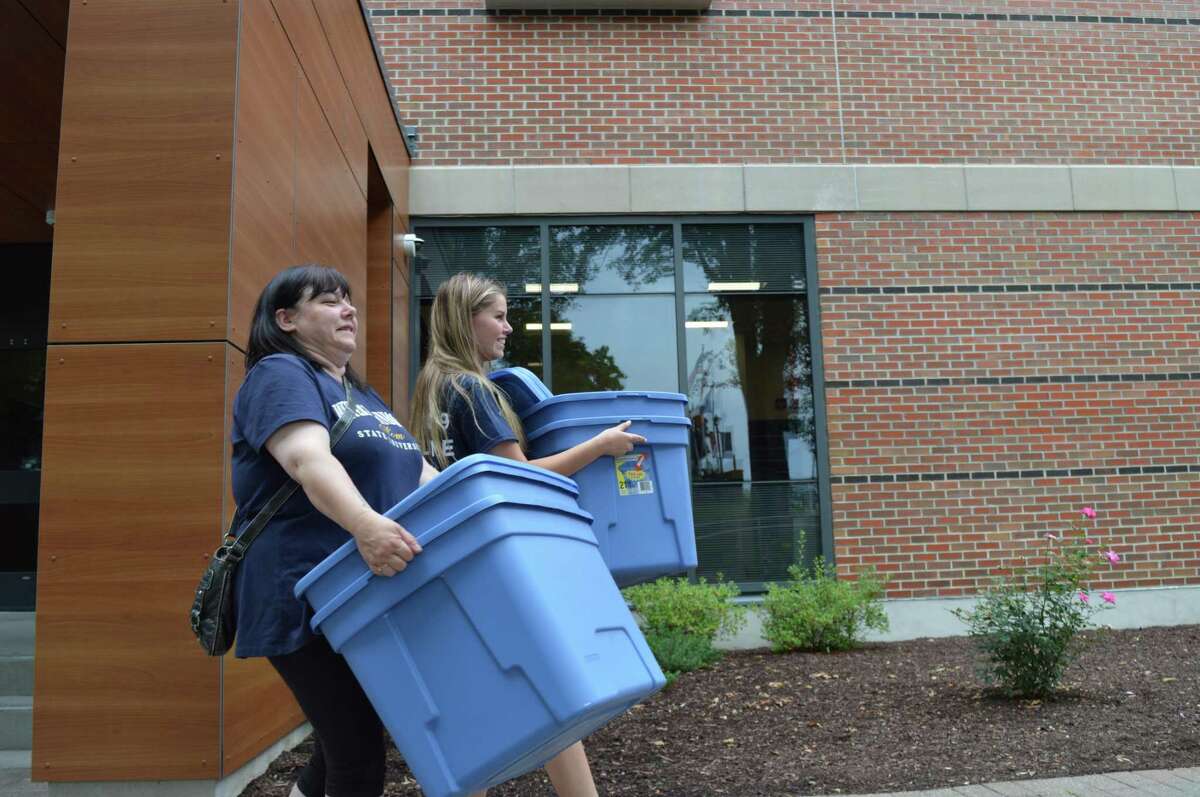 Tory Dangeonini, with mom Sheri, both of Torrington, carry bins to the dorms at Western Connecticut State University in Danbury on Friday, Aug. 23, 2019, the first move-in day of the fall semester.