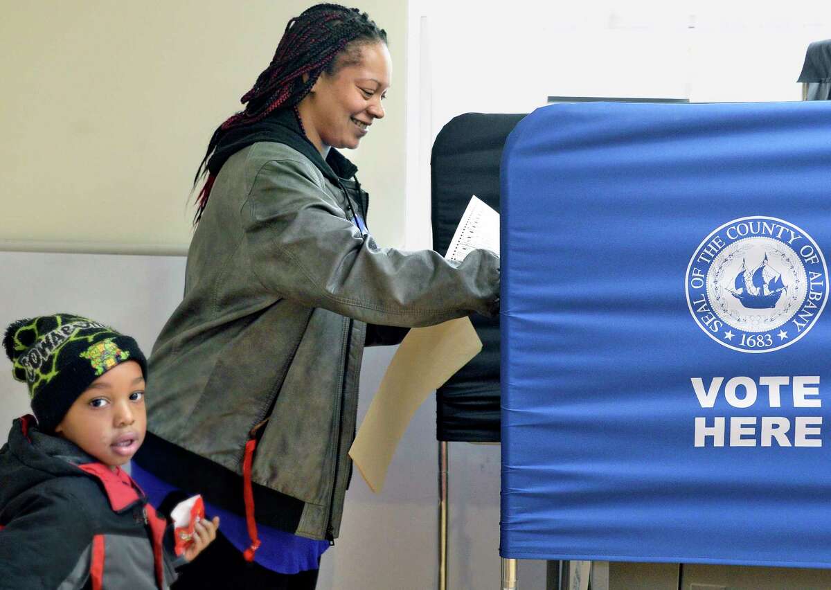 Nichole Potter casts her ballot as son Zion, 4, looks on at the Ward 3 polling station on Orange Street in Albany on Nov. 6, 2018. (John Carl D'Annibale/Times Union)