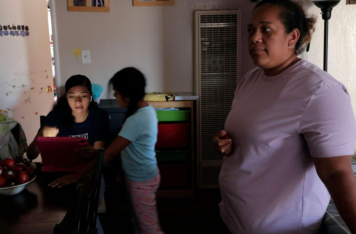 Elena Sabay, right, with her daughters, Johmara, 14, left, and Dayana, 7, right, as the Romero family spends time at home in Oakland, Calif., on Monday, July 13, 2020. Elena Sabay recently lost her job as hotel housekeeper because of business shutdowns and her husband’s, Alfredo Romero, earnings are the only thing keeping the family afloat during the pandemic.
