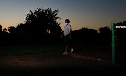 Paula Parker walks around the tennis courts at a school near her home in Houston.