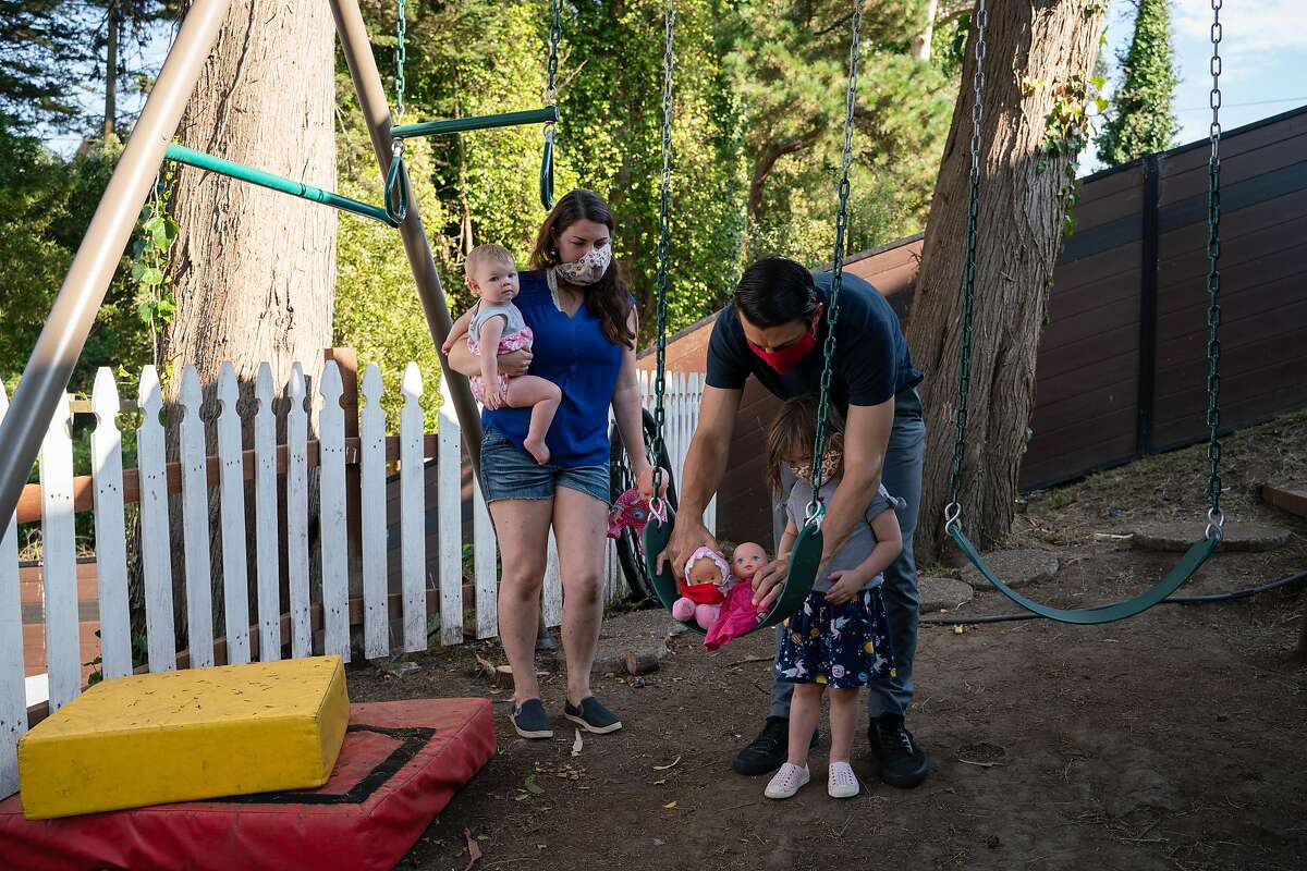 格蕾丝和亚历克斯·索比斯基和他们的女儿德西蕾和乔西在他们位于帕西菲卡家的后院玩耍。
