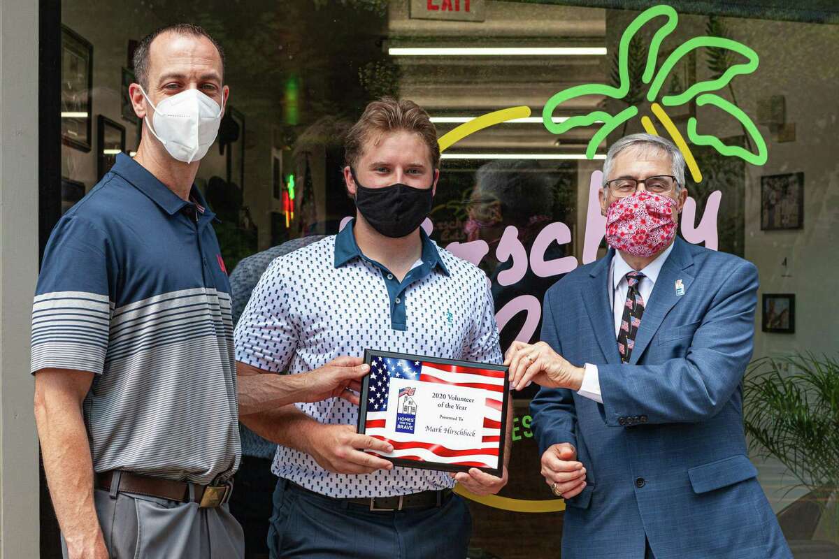 Mark Hirschbeck was named the 2020 Volunteer of the Year by Homes for the Brave. Hirschbeck was presented the award in front of his shop by Homes for the Brave Board President and Shelton Police Lt. Robert Kozlowsky, left, and Homes for the Brave CEP Vincent Santilli, right.