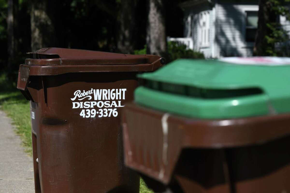 Trash cans from Robert Wright Disposal are seen along Kenwood Avenue on Thursday, Aug. 20, 2020, in Bethlehem, N.Y. Trash companies are in the midst of a marketing fight for suburban Capital Region customers. Twin Bridges recently offered a year of free trash pickup for new customers in Delmar. (Will Waldron/Times Union)