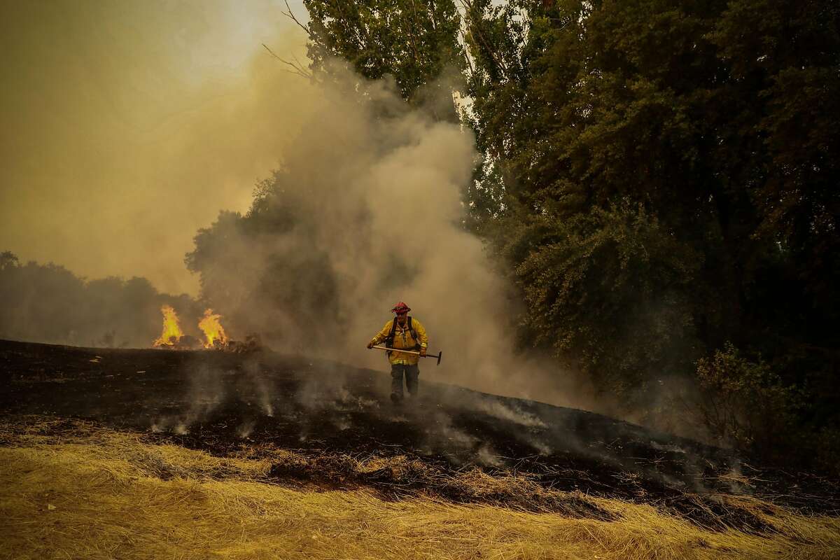 A firefighter works to contain the LNU Lightning Complex Fire off of Gibson Canyon Road in Vacaville, August 19, 2020.