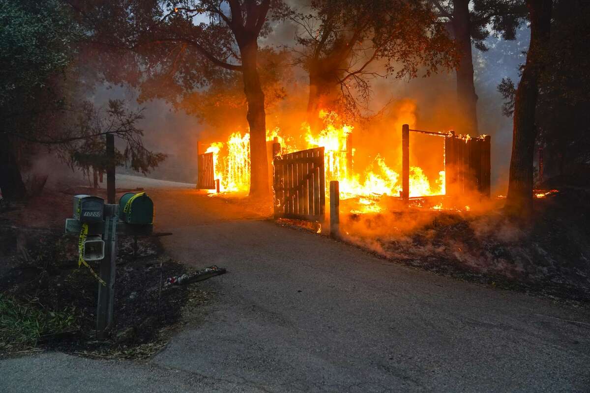 Th fence of a home is burned by the CZU August Lightning Complex Fire in Thursday, Aug. 20, 2020, near Bonny Doon, Calif.