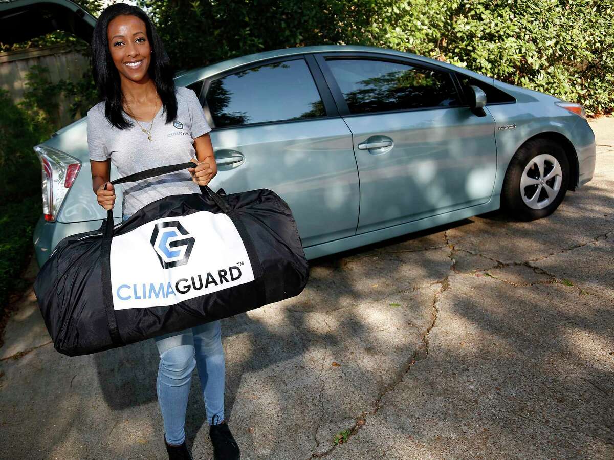 Climaguard CEO and founder Rahel Abraham demonstrates her product in Houston on Wednesday, Aug. 19, 2020. The chemical engineer is launching Climaguard, a heavy-duty plastic envelope for cars and furniture that protects them from flooding.