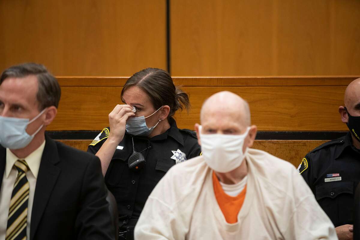 A Sacramento County Sheriff’s deputy wipes her eye as she listens in to the third day of victim impact statements and guards Joseph James DeAngelo (right) at the Gordon D. Schaber Sacramento County Courthouse on Thursday, Aug. 20, 2020, in Sacramento, Calif. DeAngelo, 74, admitted being the infamous Golden State Killer. He will be formally sentenced to life in prison on Friday under a plea agreement that allows DeAngelo to avoid the death sentence. The former police officer in California eluded capture for four decades. He has admitted 13 murders and nearly 50 rapes between 1975 and 1986.