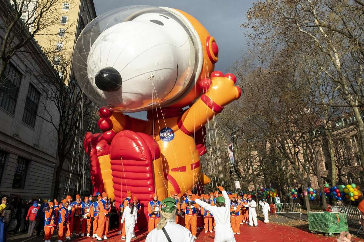 Balloon handlers fight the strong wind gusts to walk Astronaut Snoopy part of Peanuts Worldwide honoring the 50th Anniversary of the moon landing while NYPD officers watch during the 93rd Annual Macy's Thanksgiving Day Parade. Macy's still plans to hold a "reimagined" 2020 parade during the coronavirus pandemic.