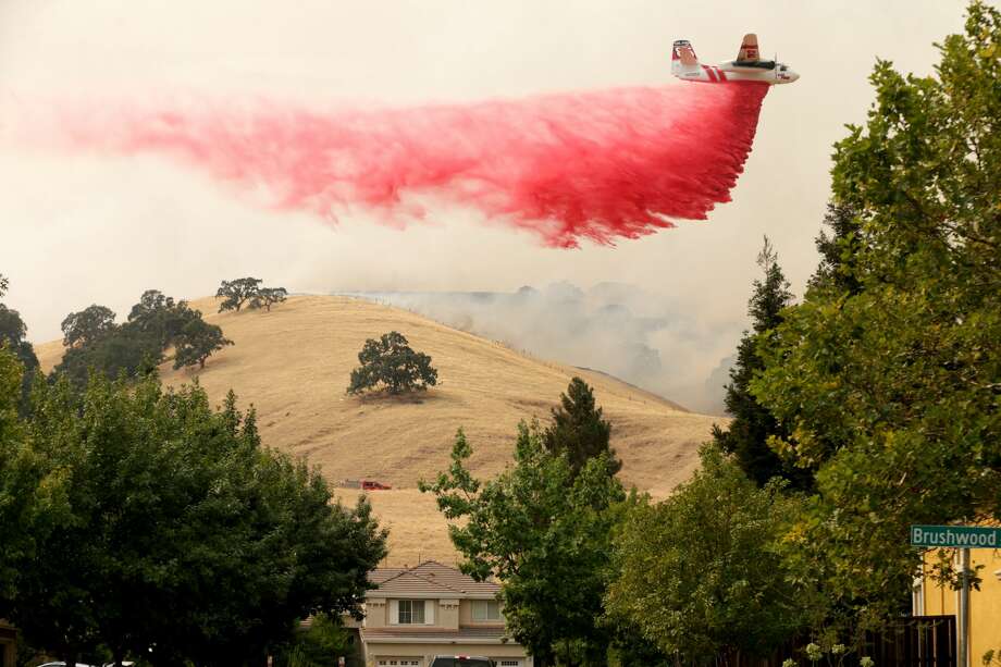 A Cal Fire tanker drops fire retardant on a hillside behind homes in the Rolling Hills neighborhood of Fairfield, Calif., on Wednesday, Aug. 19, 2020. Residents were ordered to evacuate as the LNU Lightning Complex wildfire threatened the neighborhood. Photo: MediaNews Group/East Bay Times Via Getty Images/MediaNews Group Via Getty Images / Bay Area News Group