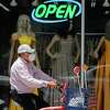 FILE - In this July 30, 2020, file photo, a cyclist passes a display window with mask covered mannequins at a dress store in McAllen, Texas. The number of laid-off workers applying for unemployment aid fell below 1 million last week for the first time since the pandemic intensified five months ago, yet still remains at a high level. (AP Photo/Eric Gay, File)
