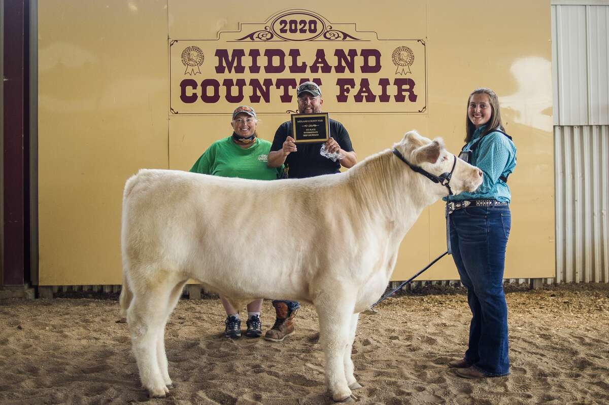 Isabelle Diehl, 14, poses for a photo with her parents and her steer after winning first place in the Intermediate Beef Showmanship contest Tuesday, Aug. 18, 2020 at the Midland County Fairgrounds. (Katy Kildee/kkildee@mdn.net)