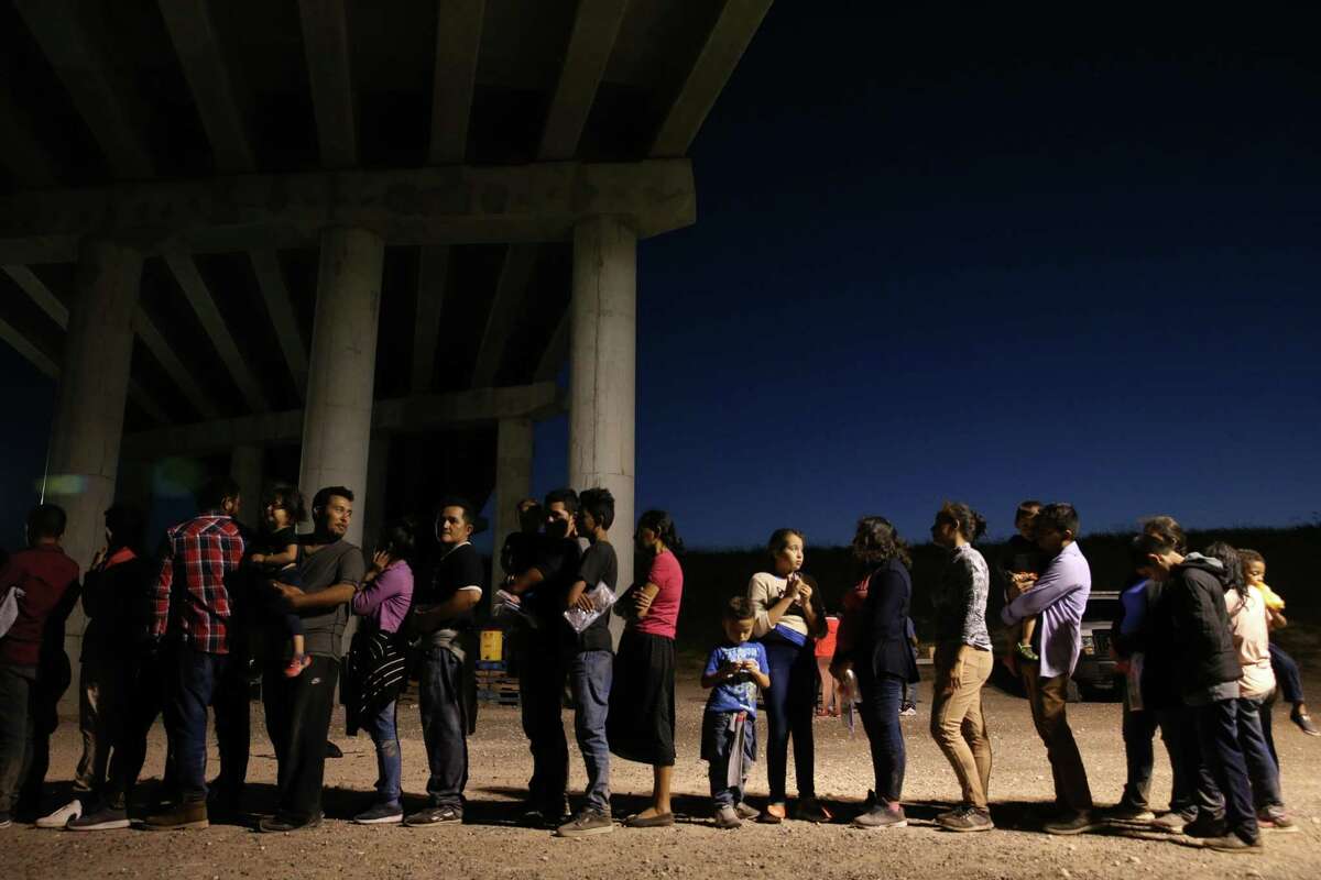 NOT FOR PUBLICATION US Border Patrol agents gather information on a large group of mostly Central American migrants that turned themselves into the agents by the Anzalduas International Bridge in Hidalgo County, Texas, Thursday, July 18, 2019.