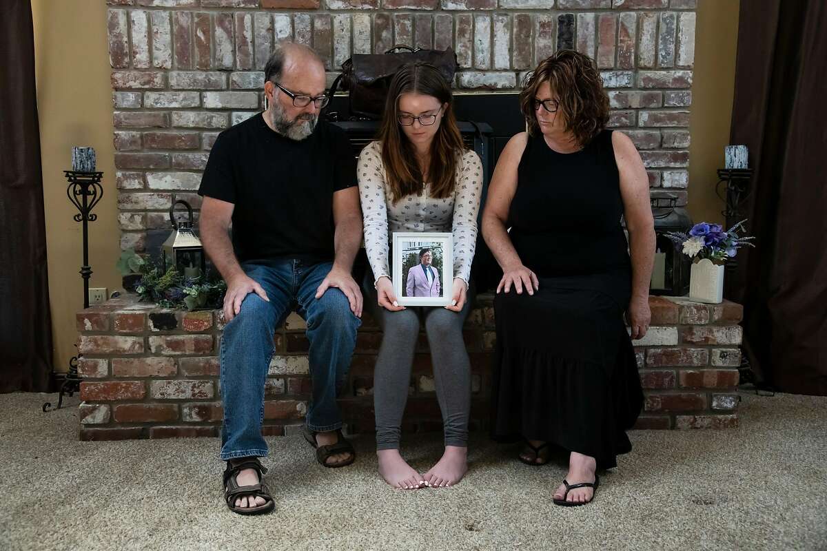 Phillip Smith, left, Madi Smith, center, and Michelle Rode-Smith, right, family of Seth Smith, pose for a portrait at their home in Clarksburg, Calif, on Monday, August 10, 2020. Seth Smith, a 19-year-old UC Berkeley student, was killed in Berkeley, Calif. on June 15, 2020. Two months and a $50,000 reward later, police still don't have a suspect and his traumatized parents are searching for answers as they help Seth's younger sister prepare to start college.