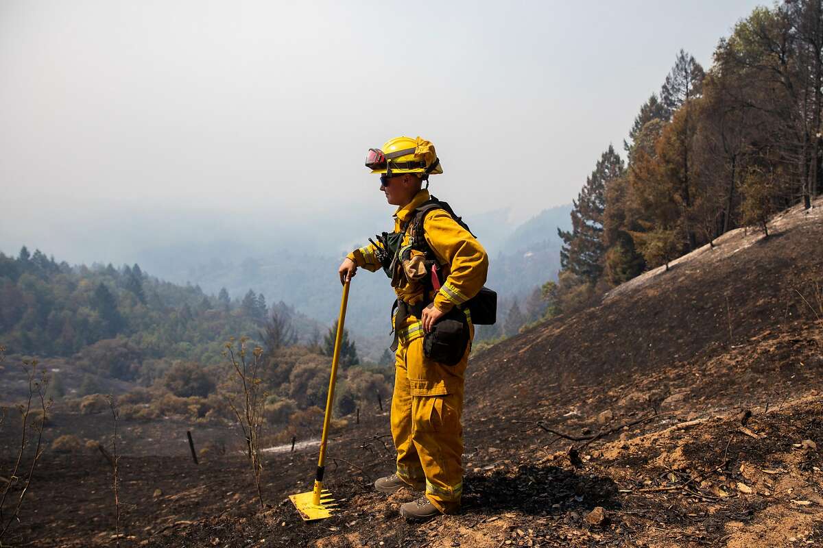 A firefighter works to rake a fire break along McCray Ridge Road after the Walbridge Fire burned through the area along Armstrong Redwoods Natural Preserve in Guerneville, Calif. Friday, August 21, 2020. Firefighters are working to hold the southern fire line north of Sweetwater Springs Road and are concerned that if it jumps, it will make its way down the hill toward the populated towns of Rio Nido and Guerneville. The Walbridge Fire stands at 21,125 acres and is 0% contained as of Friday.