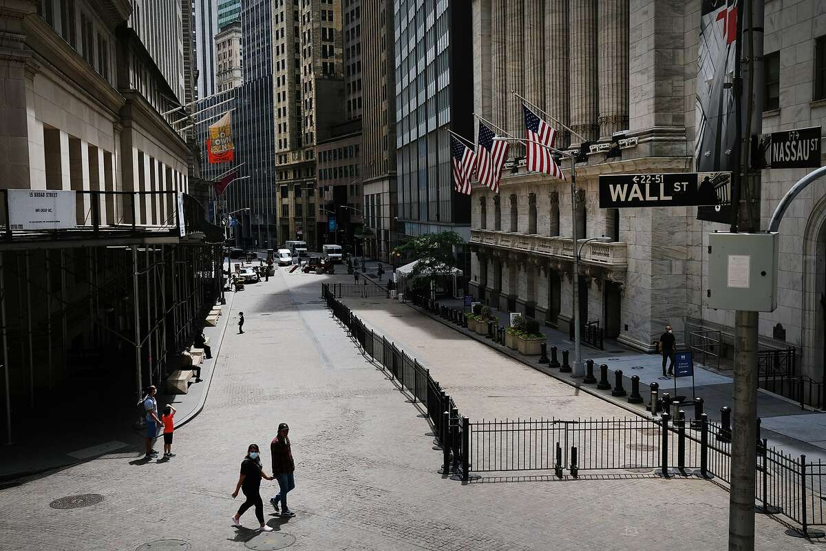 People walk by the New York Stock Exchange (NYSE) in an empty Financial District on June 15, 2020 in New York City.  The billboard will remain up in Los Angeles through Feb. 25. According to an interview with NBC New York, the artists hope to bring the campaign back to the city through billboard and subway ads.
