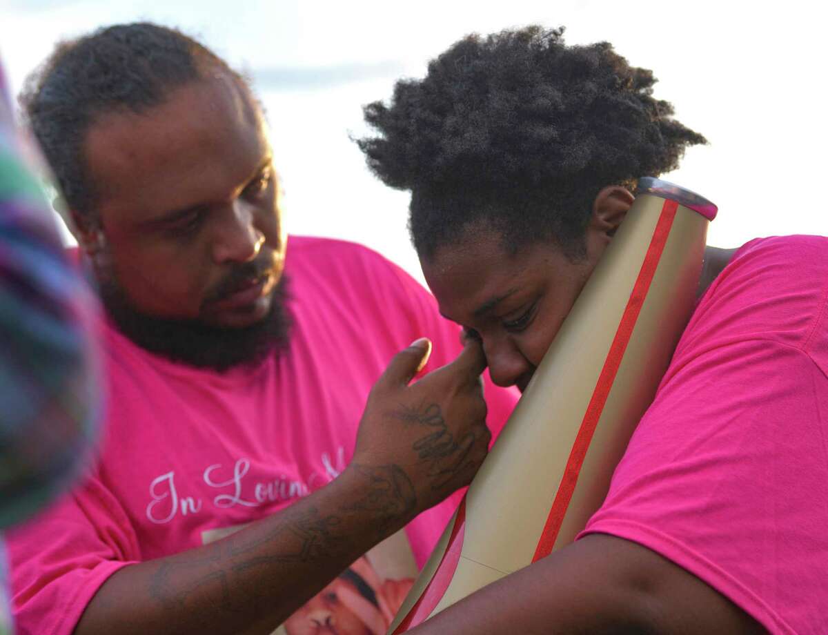 Michael Crawford wipes away the tears of his wife, Patricia, as she holds their daughter’s cheerleader megaphone during a vigil on Friday, Aug. 21, 2020. Donita Elizabeth Henry-Phillips, 11, died from gunshot wounds suffered in the 5500 block of Walzem on Saturday. A second victim is hospitalized. No arrests have been made.