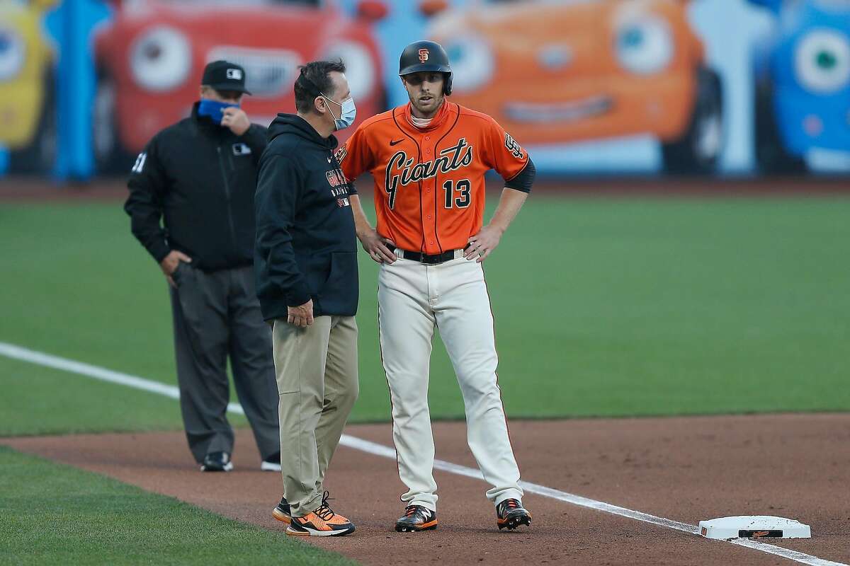 SAN FRANCISCO, CALIFORNIA - AUGUST 21: Austin Slater #13 of the San Francisco Giants talks to a member of the medical staff before exiting the game against the Arizona Diamondbacks in the bottom of the first inning at Oracle Park on August 21, 2020 in San Francisco, California. (Photo by Lachlan Cunningham/Getty Images)